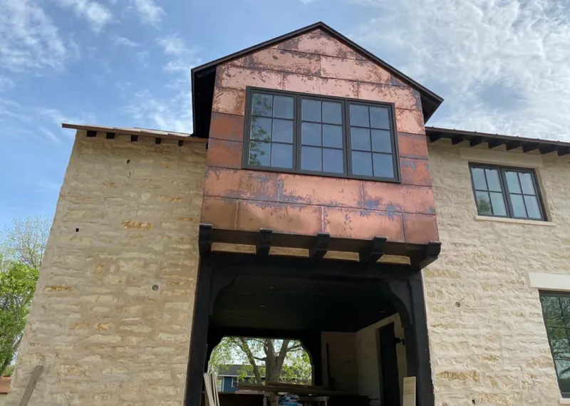 Copper metal panel facade on a stone building for Roof Repair in Greenville